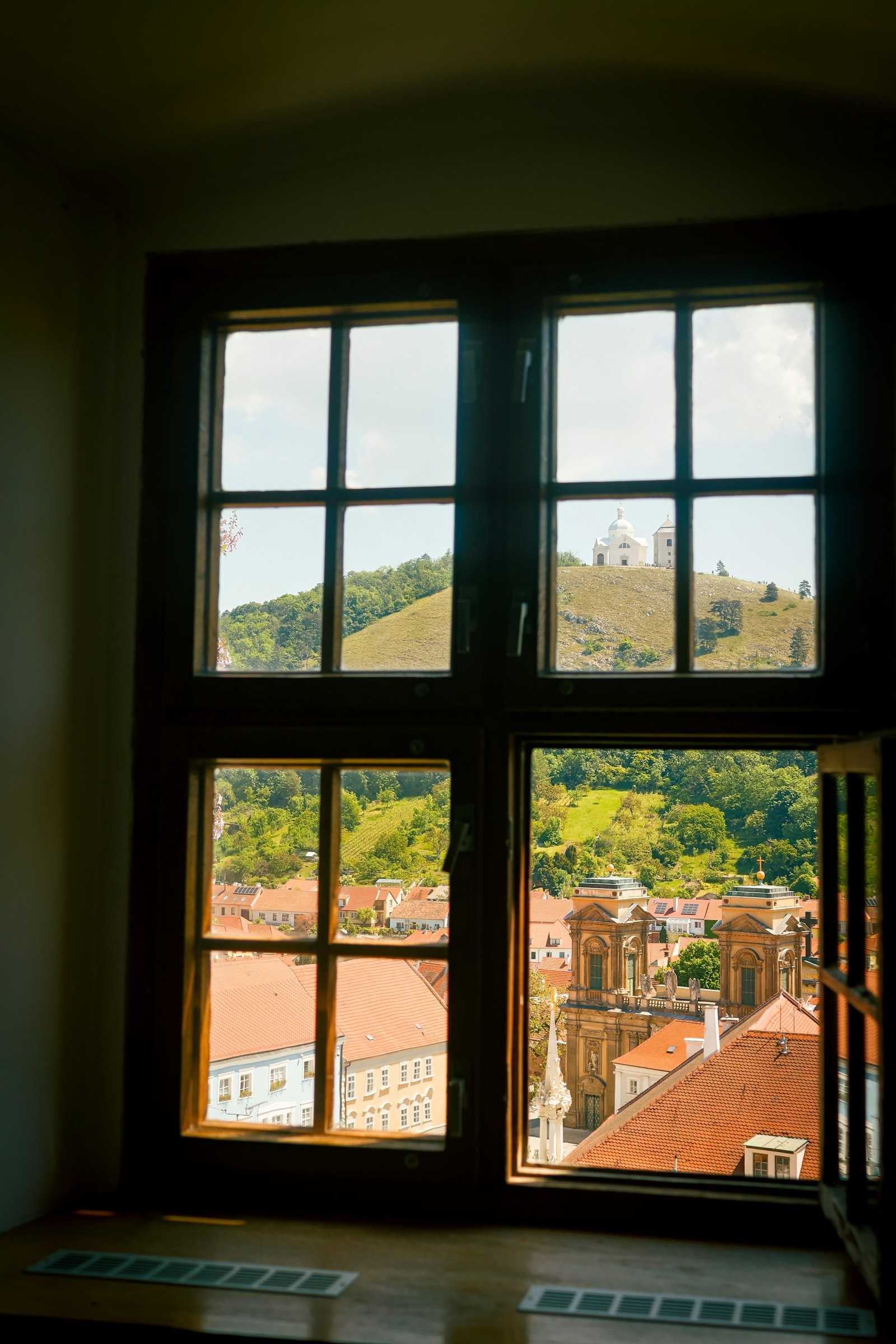 Blick aus dem Fenster über die Dächer von Mikulov auf den Heiligen Berg