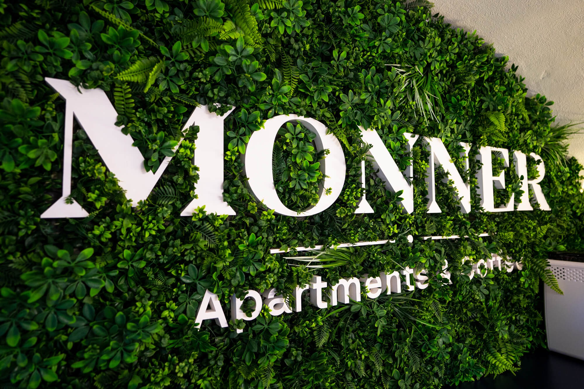 Mooswand mit dem Monner-Logo